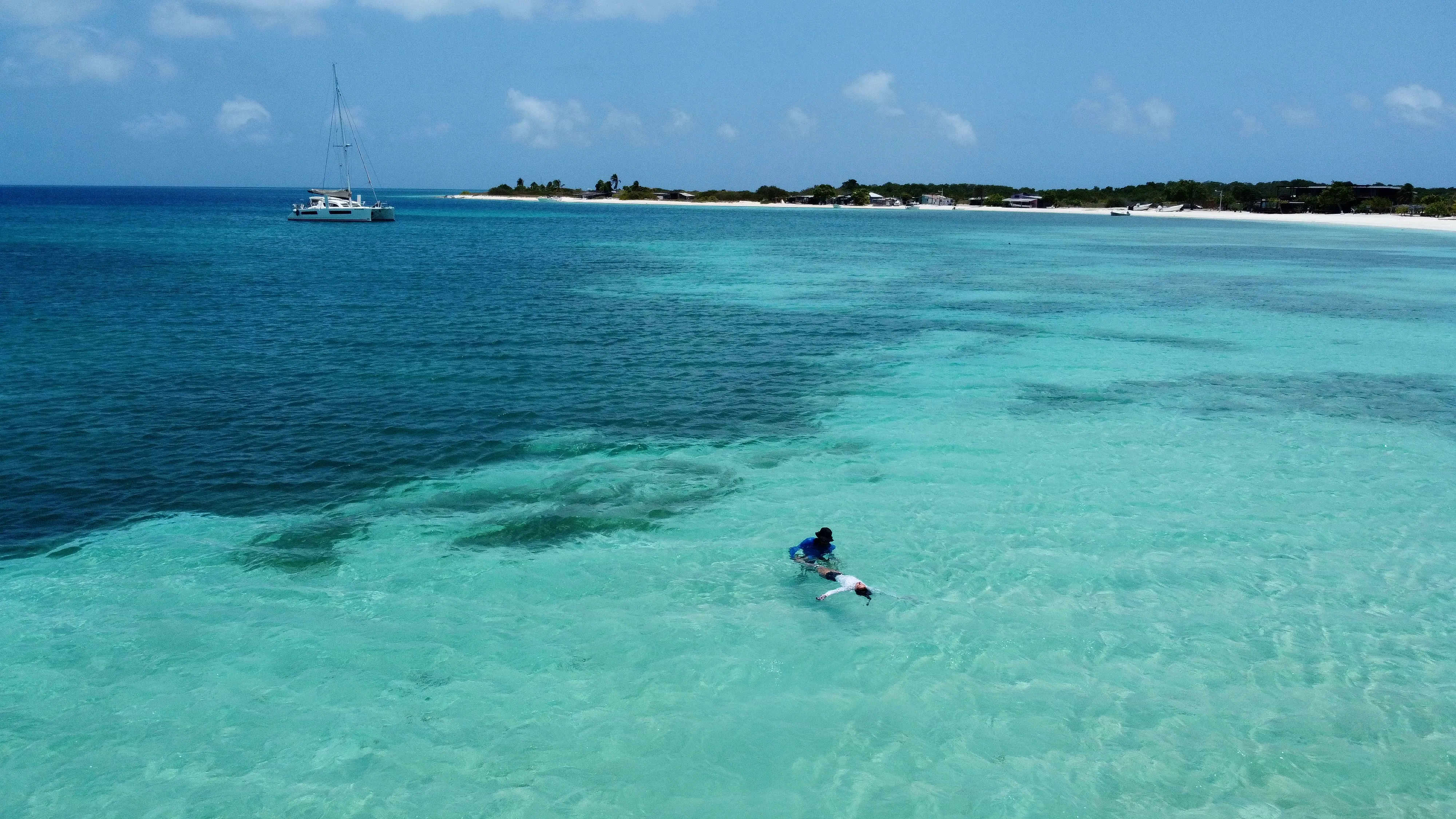 A snorkeler in the shallow turquoise water off a San Blas island