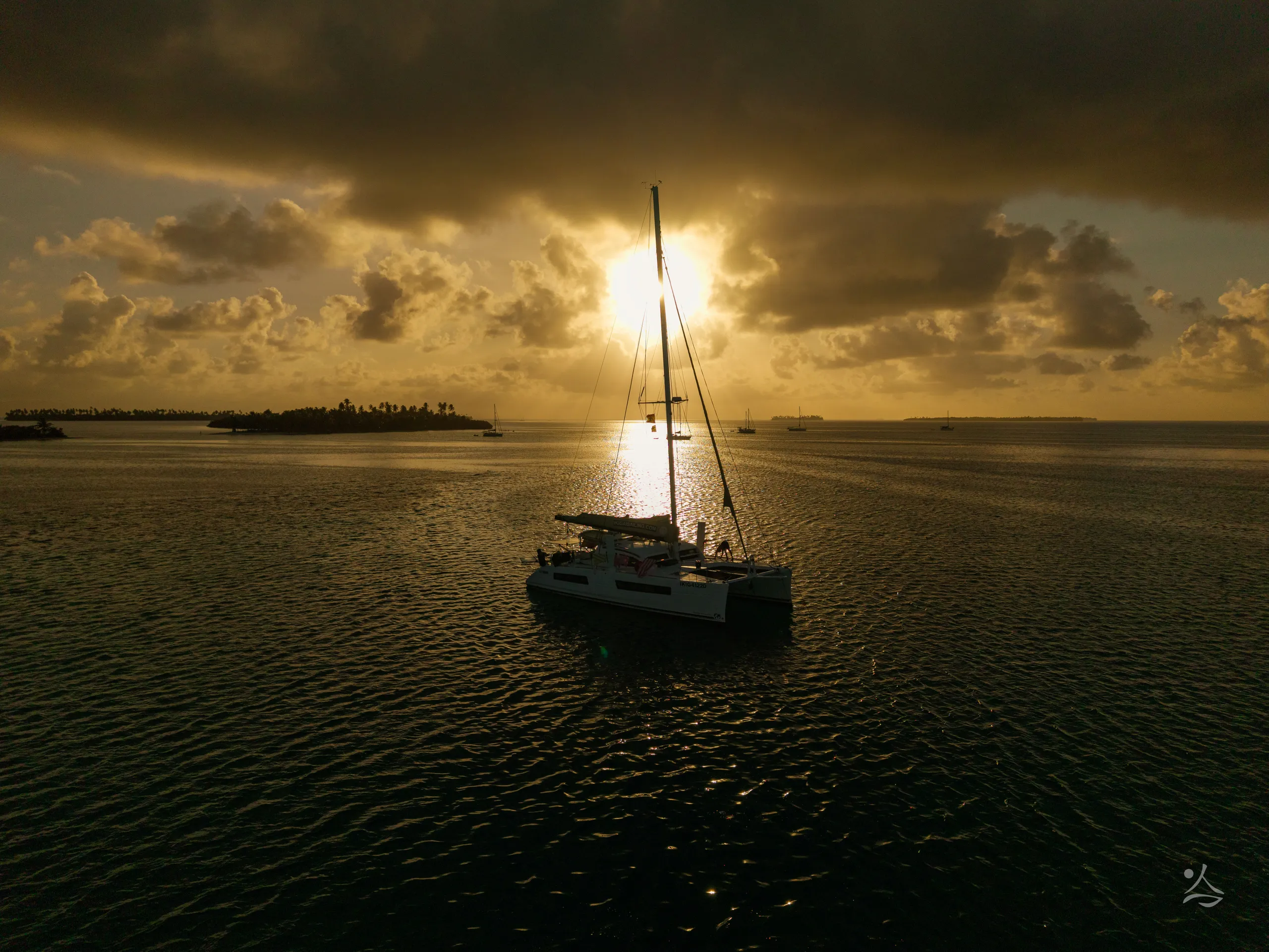 The catamaran Ikigai backlit at sunset
