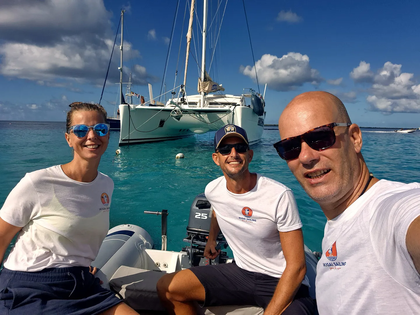 Three of us on the tender in front of IKIGAI at anchor