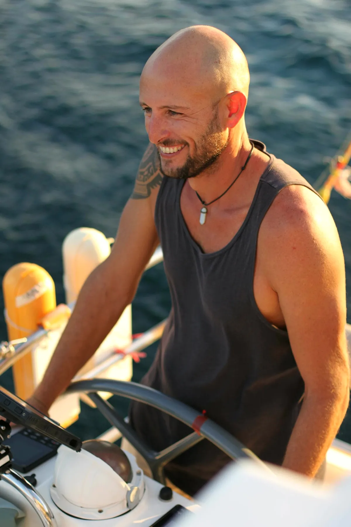 Luca, founder and skipper, at the helm of the catamaran Ikigai